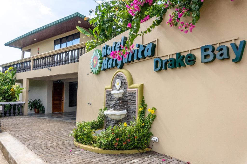 "Drake Bay Hotel Margarita, Costa Rica text overlay multicoloured letters above image of central fountain."